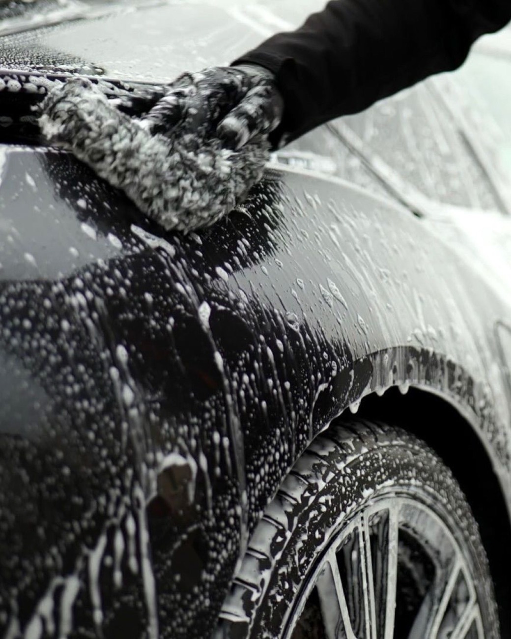 Wash mitt gliding across a foamed black fender